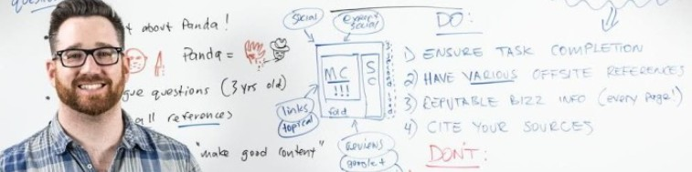 Josh Bachynski smiling in front of an SEO research whiteboard
